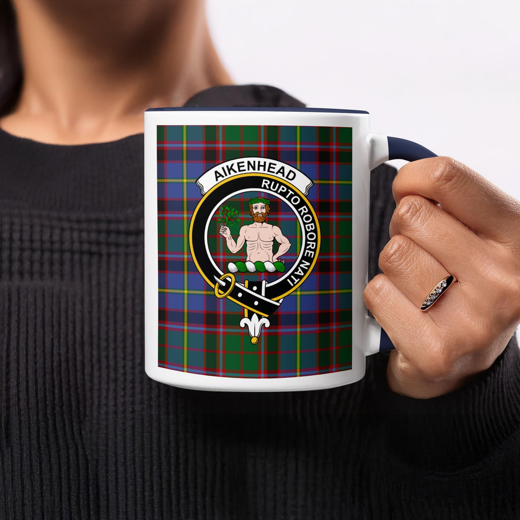 Close-up lifestyle view of Aikenhead Scottish family crest artwork on a navy 11 oz accent mug with a tartan background