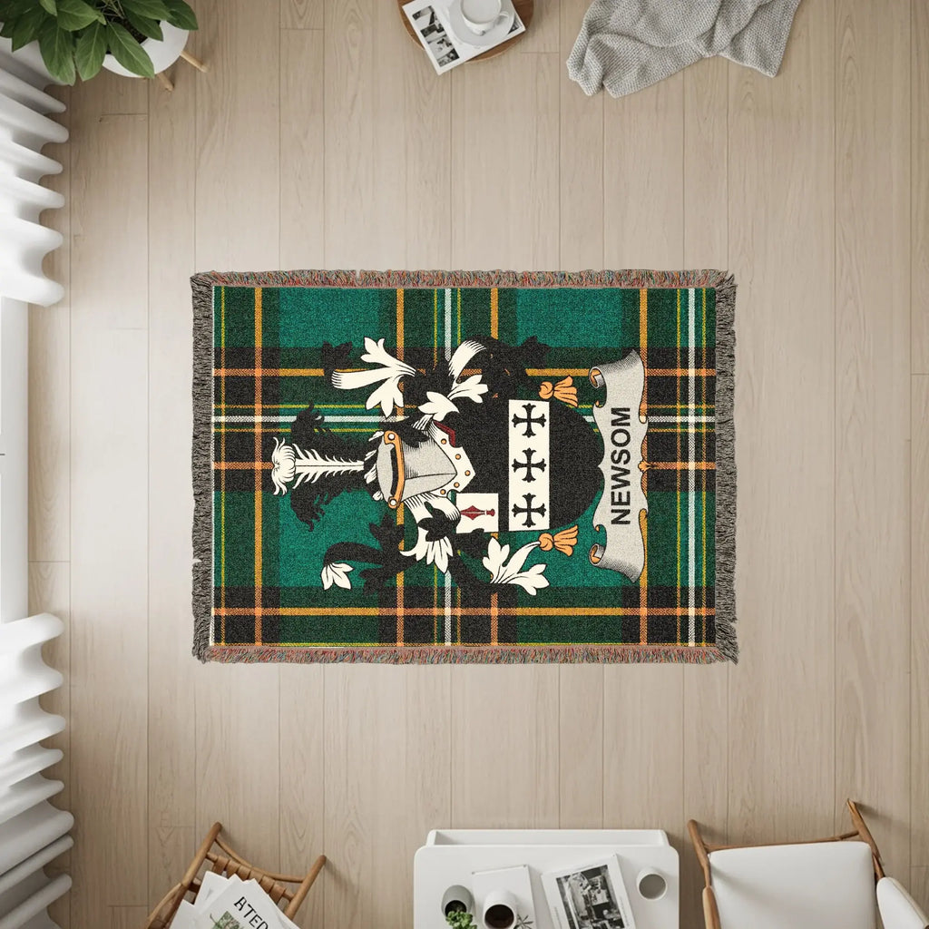 Woven blanket with the Newsom family crest on a plaid background.