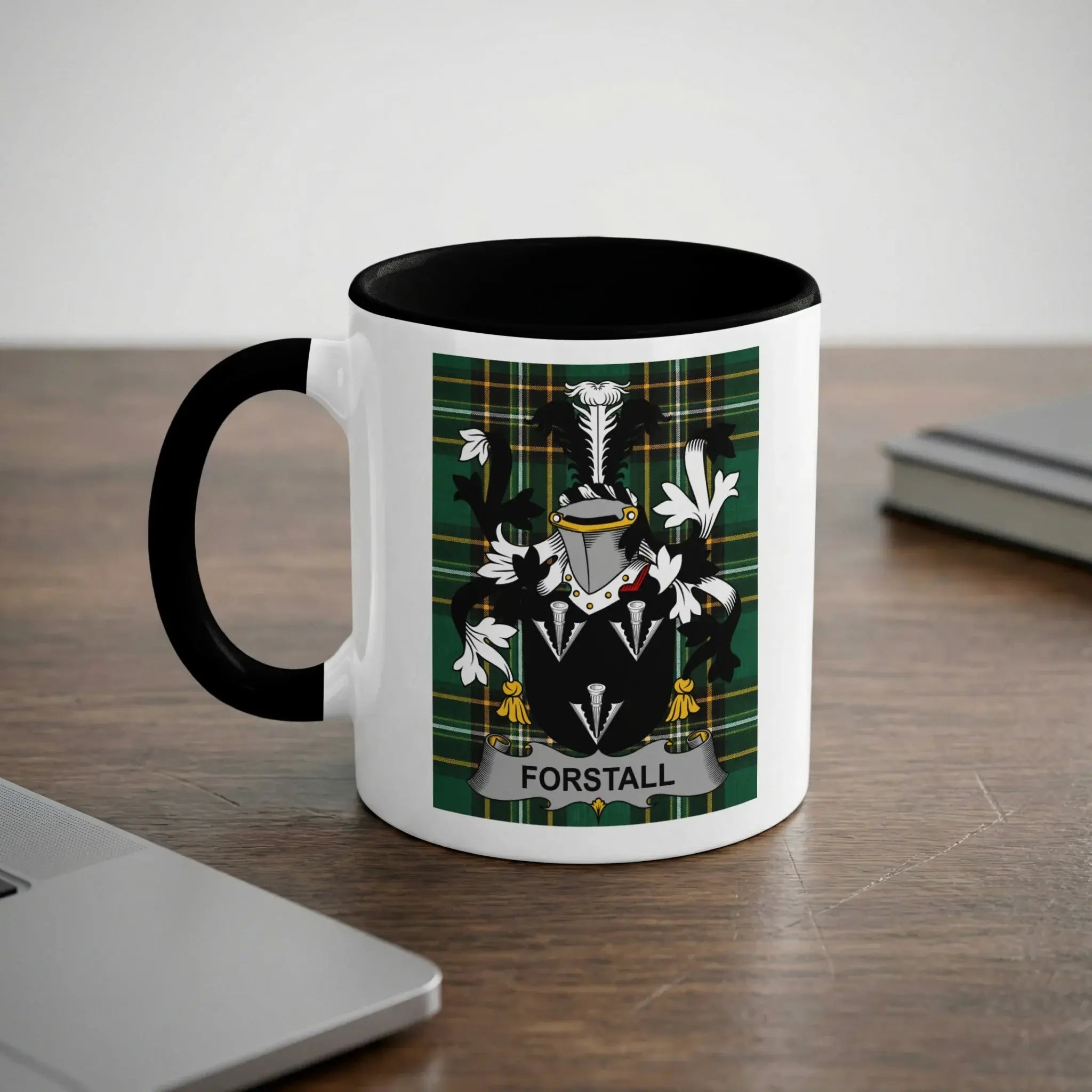 White mug with black handle displaying the Forstall family crest on a wood surface.