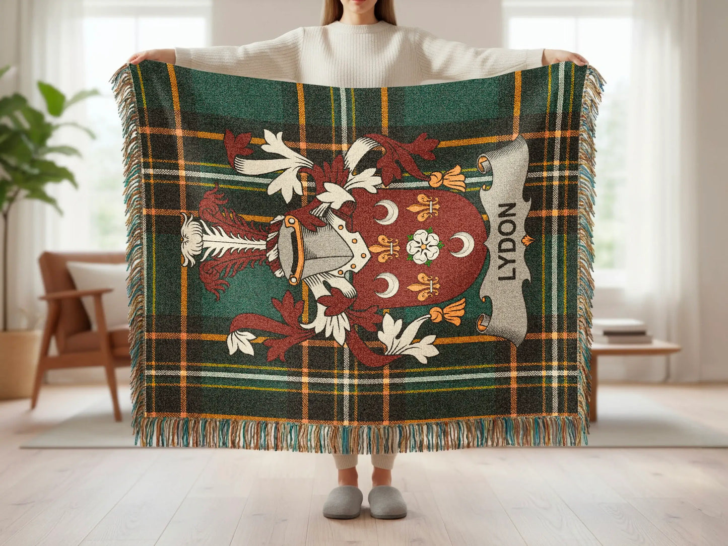 Plaid blanket with a crest and "LYDON" text held up by a person.