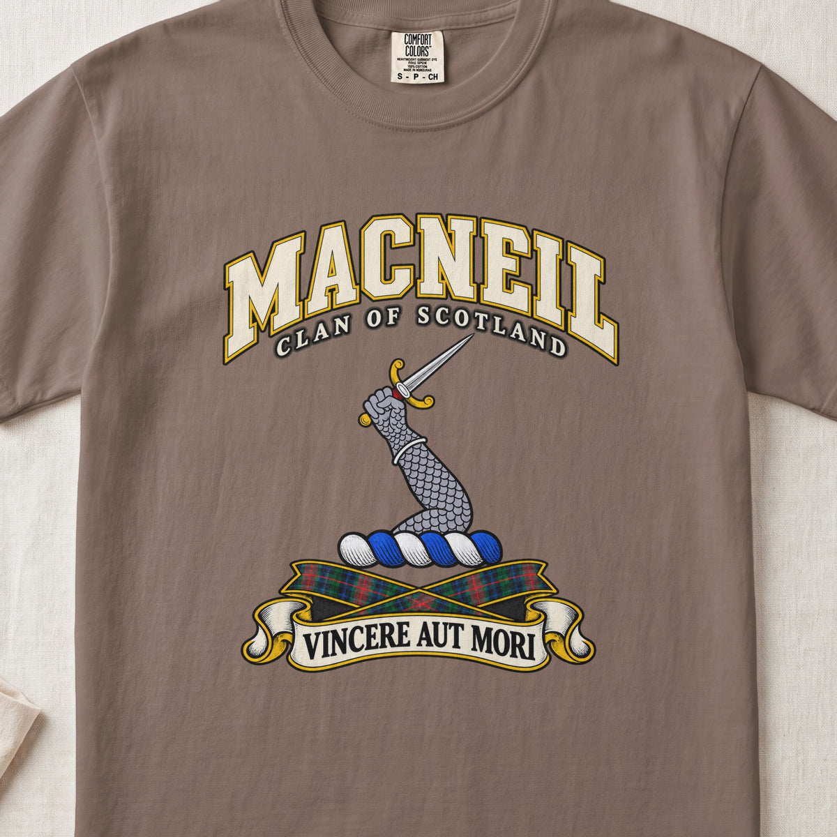 MacNeil Scottish clan T-shirt in Espresso, front view with an armoured arm holding a dagger and motto design.
