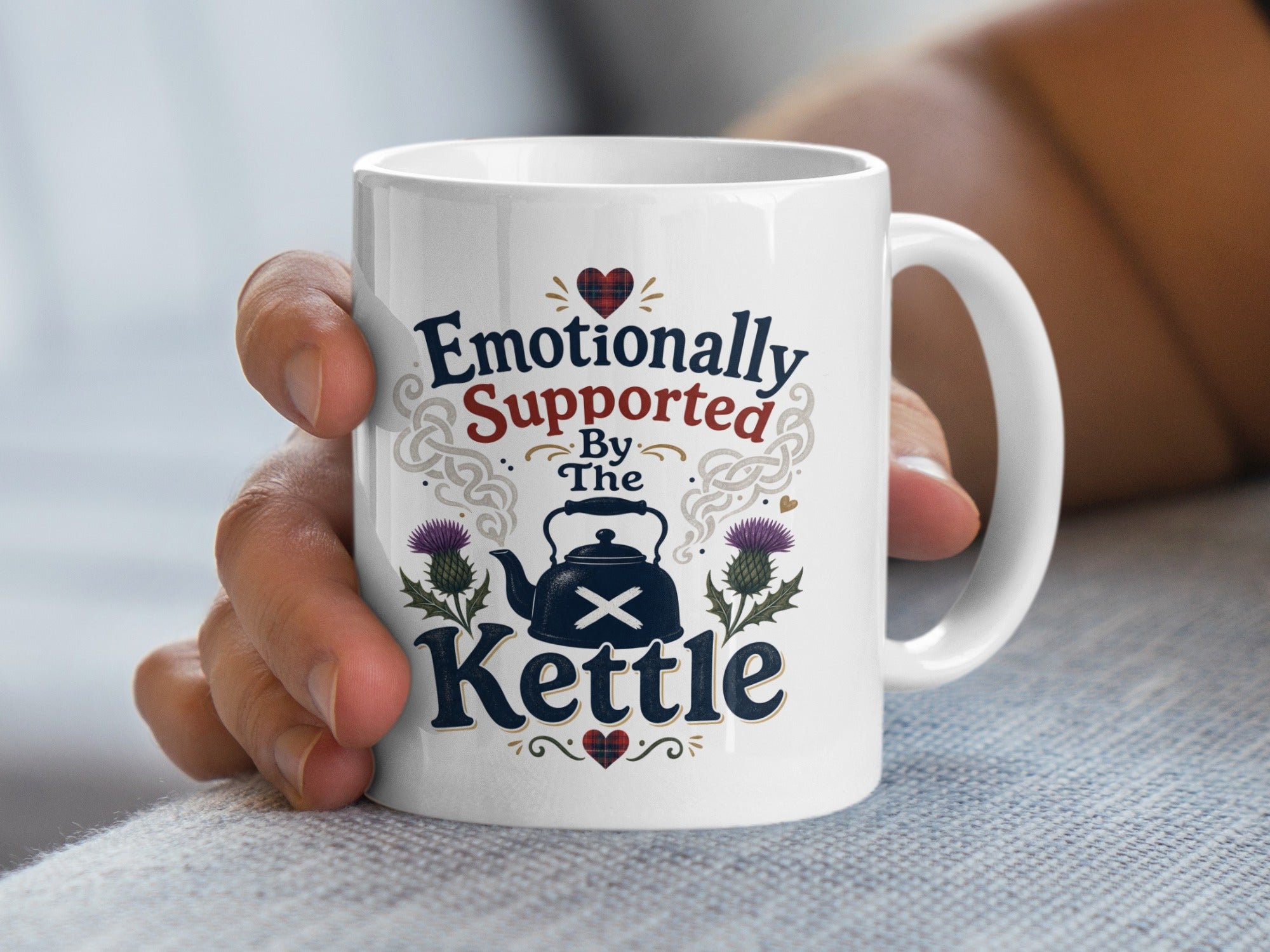 White mug with "Emotionally Supported By The Kettle" text and Scottish thistle design.