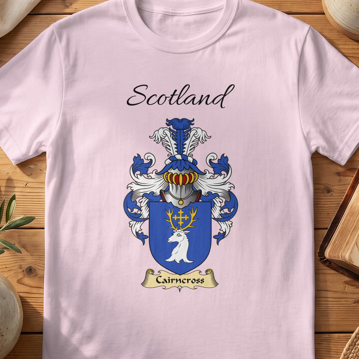 Light Pink Cairncross Scottish family shield T-shirt featuring a white stag head with gold antlers on blue