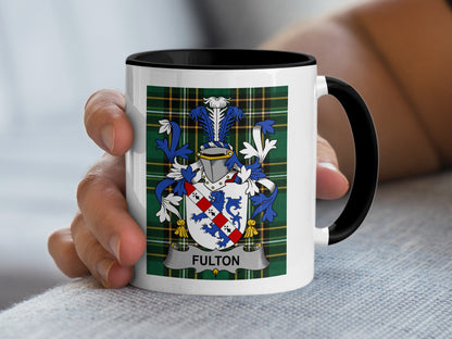 White mug with a green tartan pattern and the Fulton family crest.