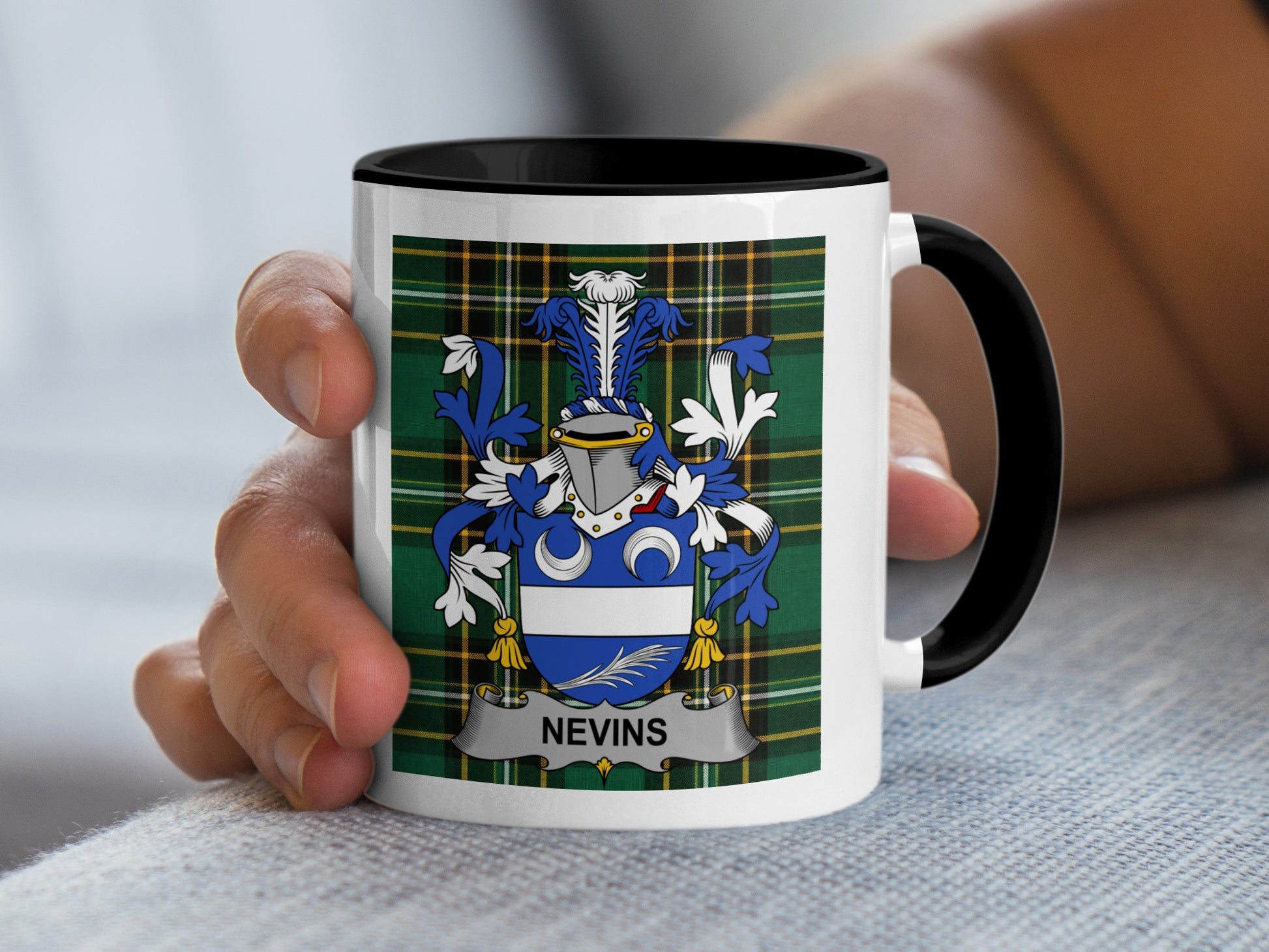 White mug with black handle featuring the Nevins family crest and plaid pattern.