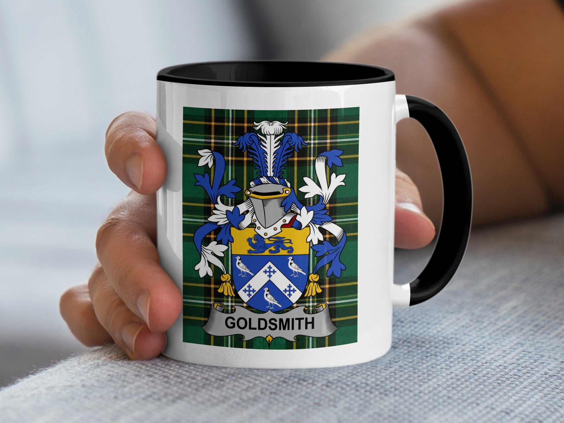 Mug with crest and "Goldsmith" text held by a hand.