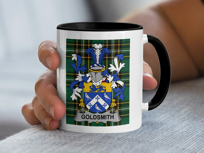 Mug with crest and "Goldsmith" text held by a hand.