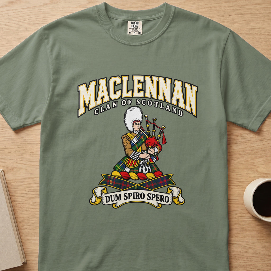 MacLennan clan crest with tartan-clad piper on a sage green Comfort Colors T-shirt, front view