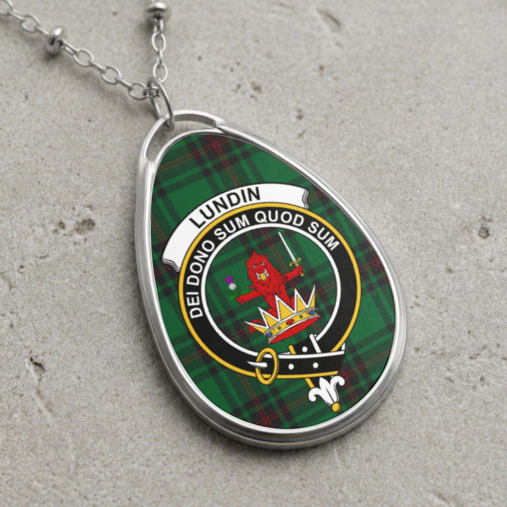 Oval pendant necklace with Lundin tartan and crest: red lion, crown, motto.
