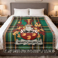 Green plaid throw blanket with Whitchurch family crest on a bed.
