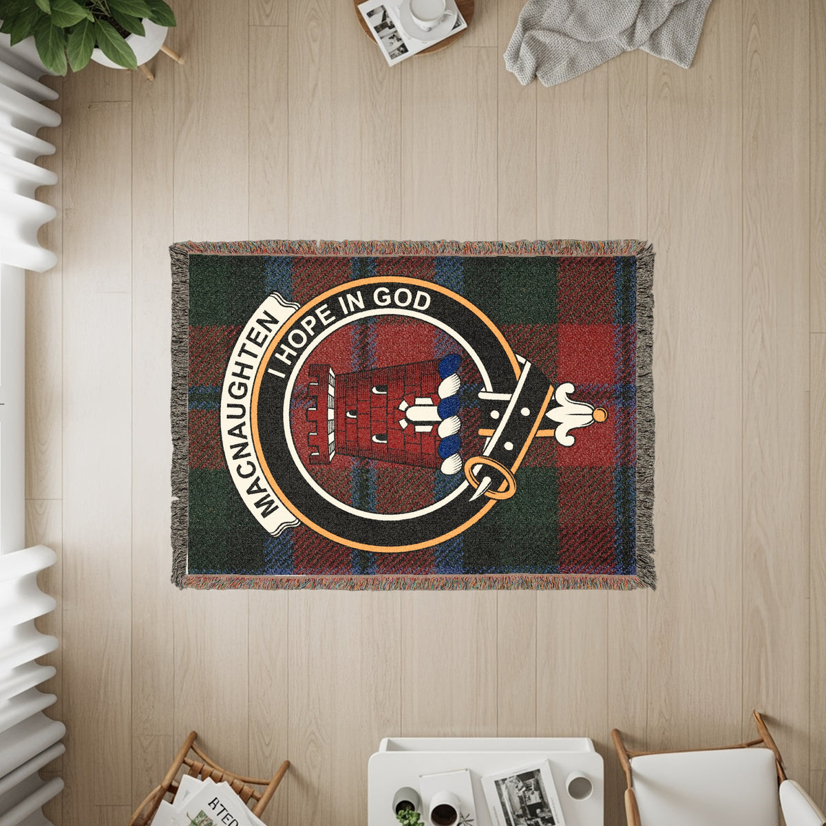 MacNaughten woven blanket displayed on a wall, featuring the crest badge and tartan background