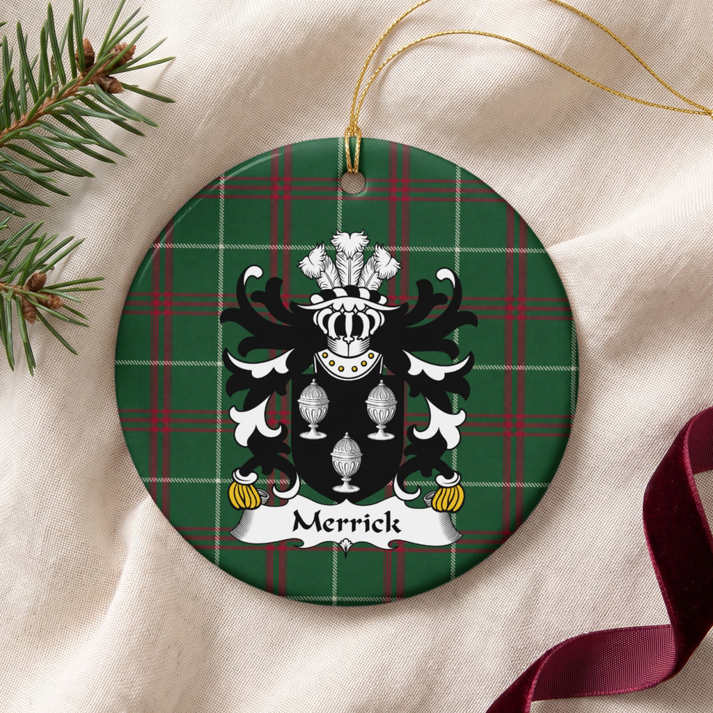 Merrick ornament on cream fabric with gold string, evergreen and burgundy ribbon; three white covered cups on a black shield on Welsh national tartan.