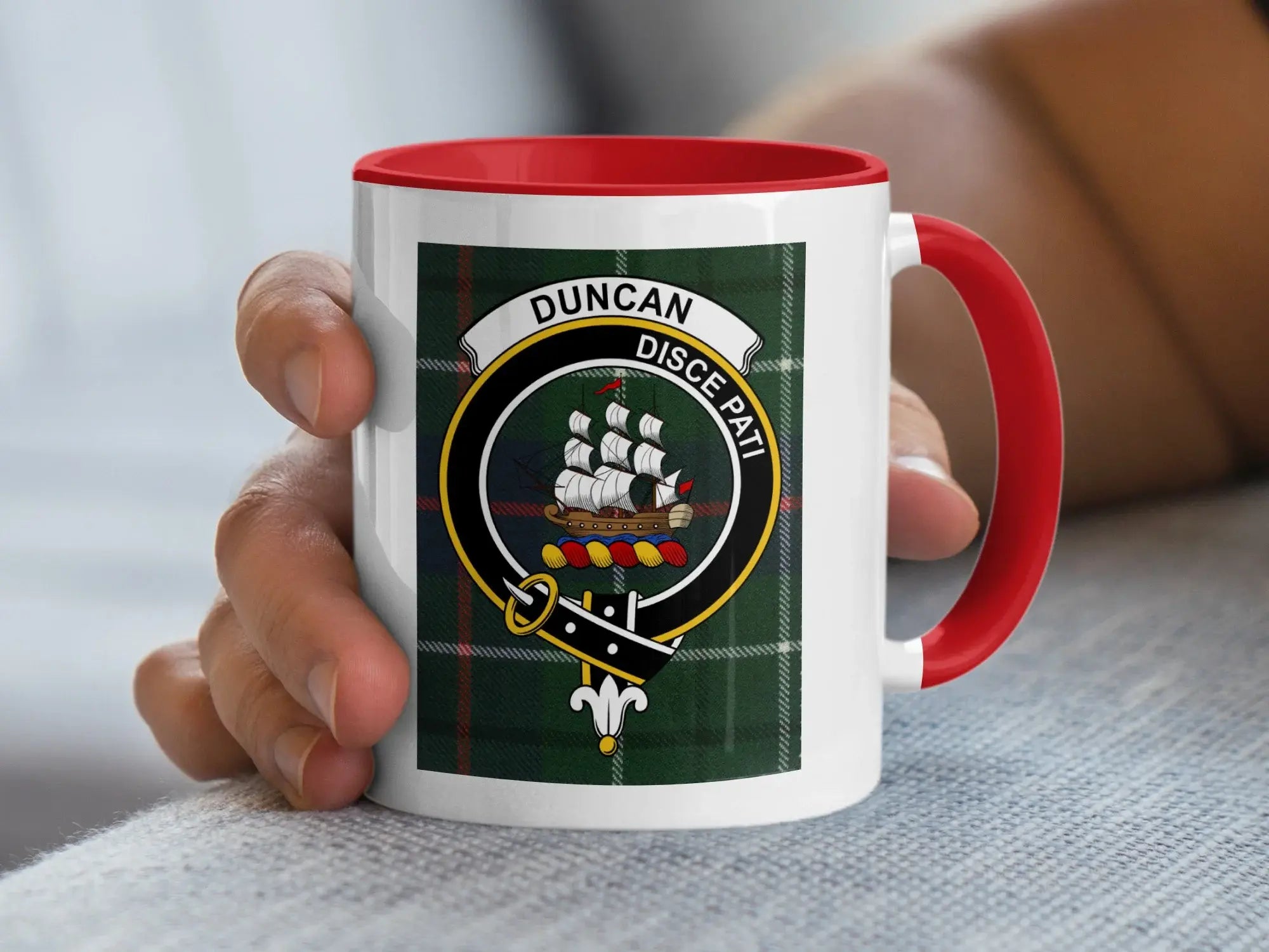 White mug with red handle, featuring a Scottish clan crest on tartan.