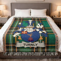 Tartan blanket featuring the Turnly family crest on a bed.