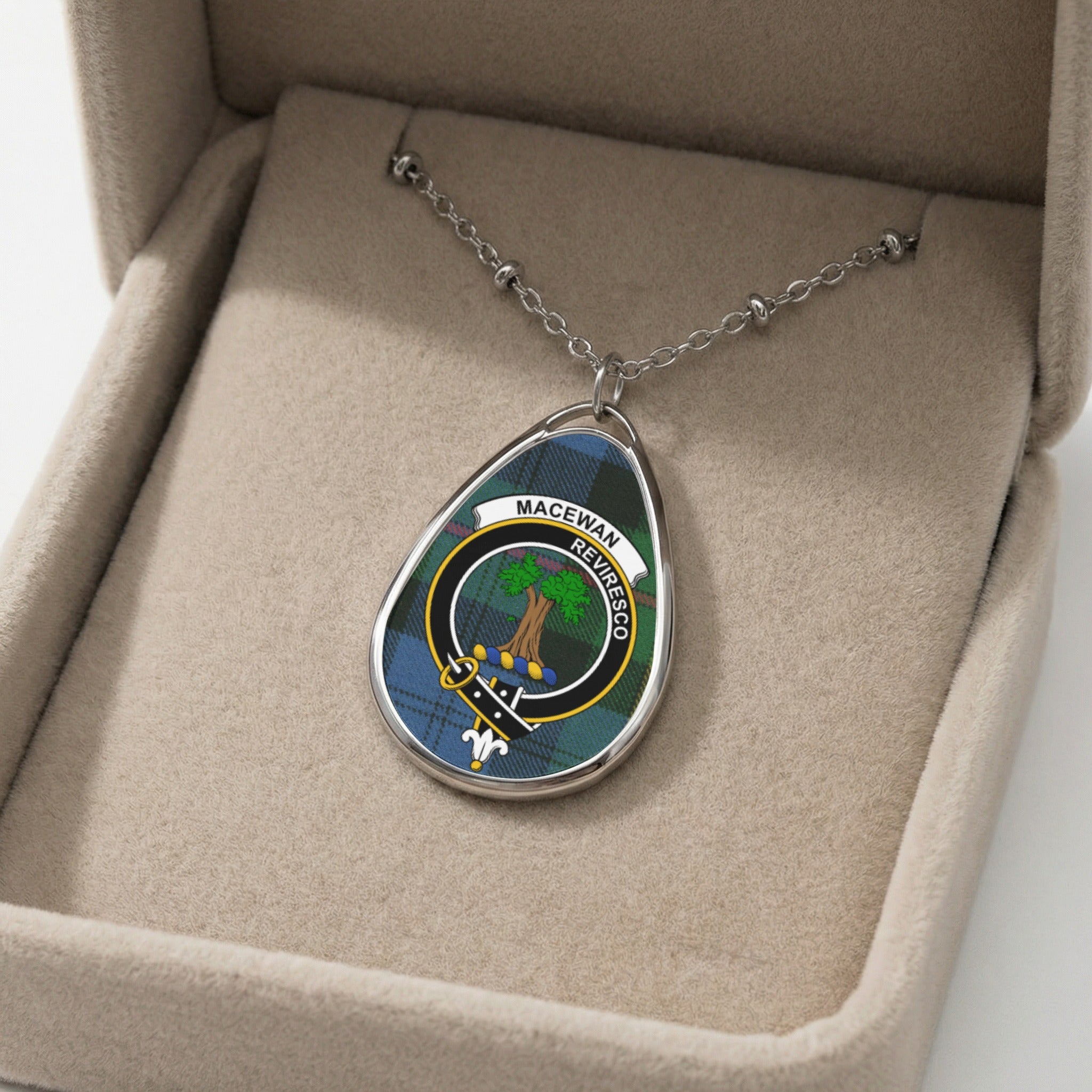 Oval pendant necklace with MacEwan clan crest on tartan in a jewelry box.