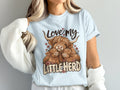 Model wearing the Love My Little Herd Highland cow Comfort Colors T-shirt in Chambray