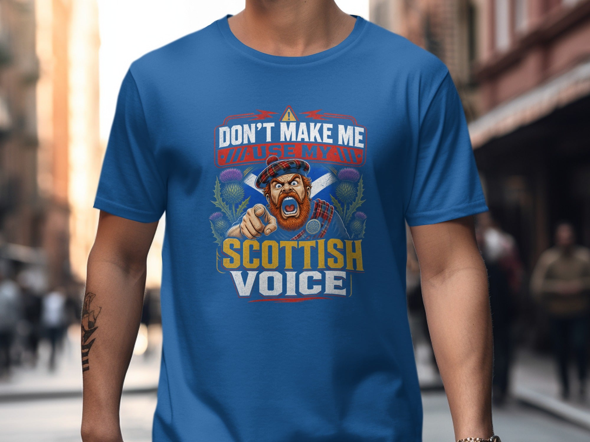 Blue t-shirt graphic featuring a Scottish man pointing and text "Don't Make Me Use My Scottish Voice".