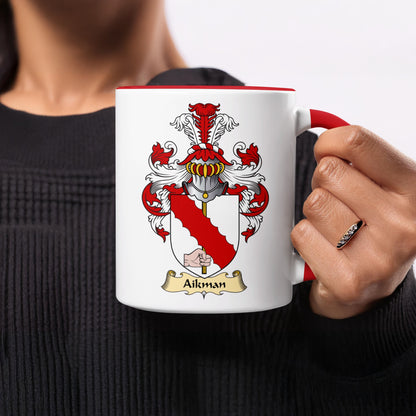 White mug with red handle, featuring Aikman coat of arms and name.