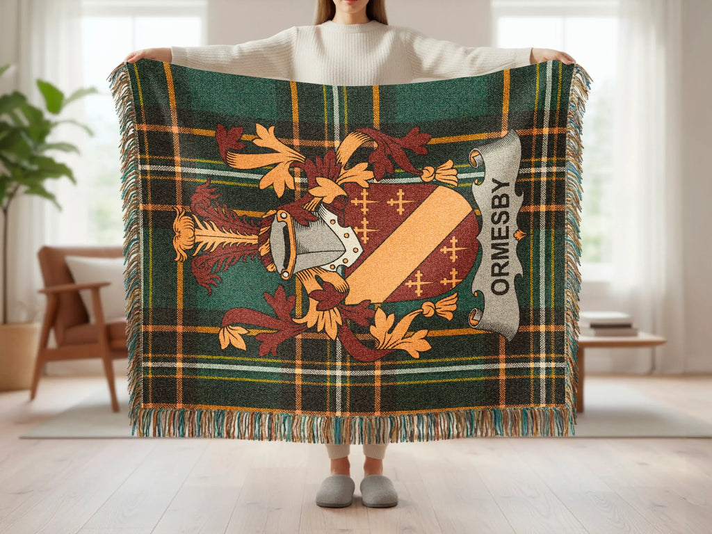 Tartan blanket with crest displaying "ORMESBY" held by a person.