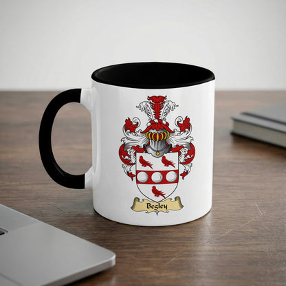 White mug with black rim featuring a coat of arms and "Begley" text.