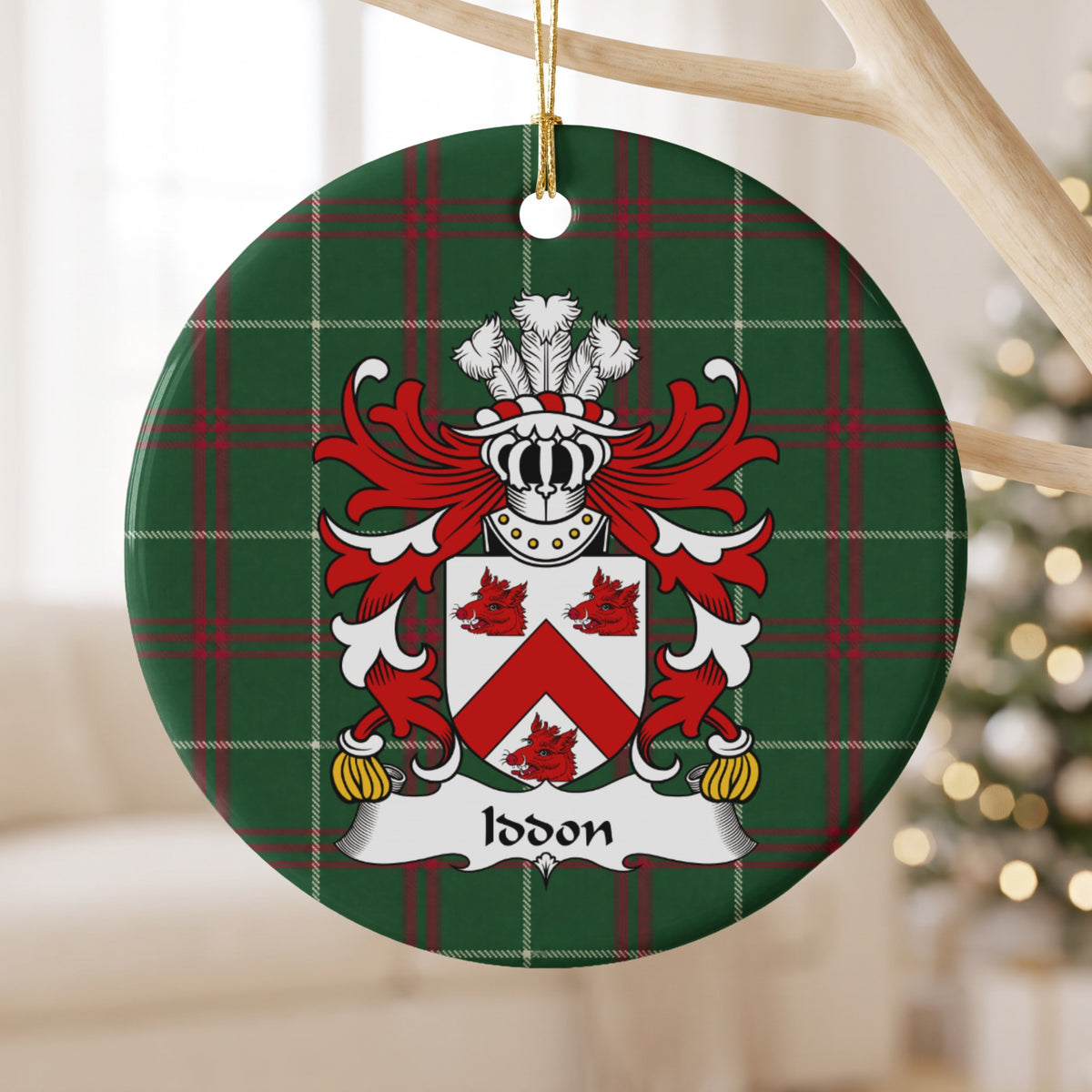Iddon ornament hanging from a pale wooden branch; a red chevron and three red boar heads on a white shield on Welsh national tartan.
