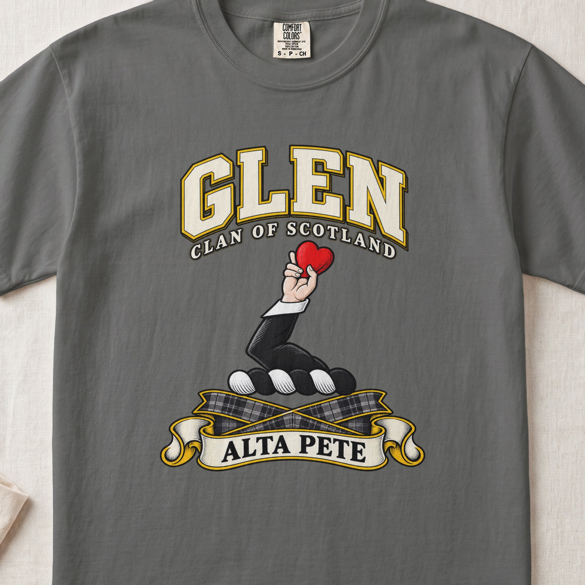 Glen Scottish clan T-shirt in Pepper, front view with a hand holding a red heart and motto banner.