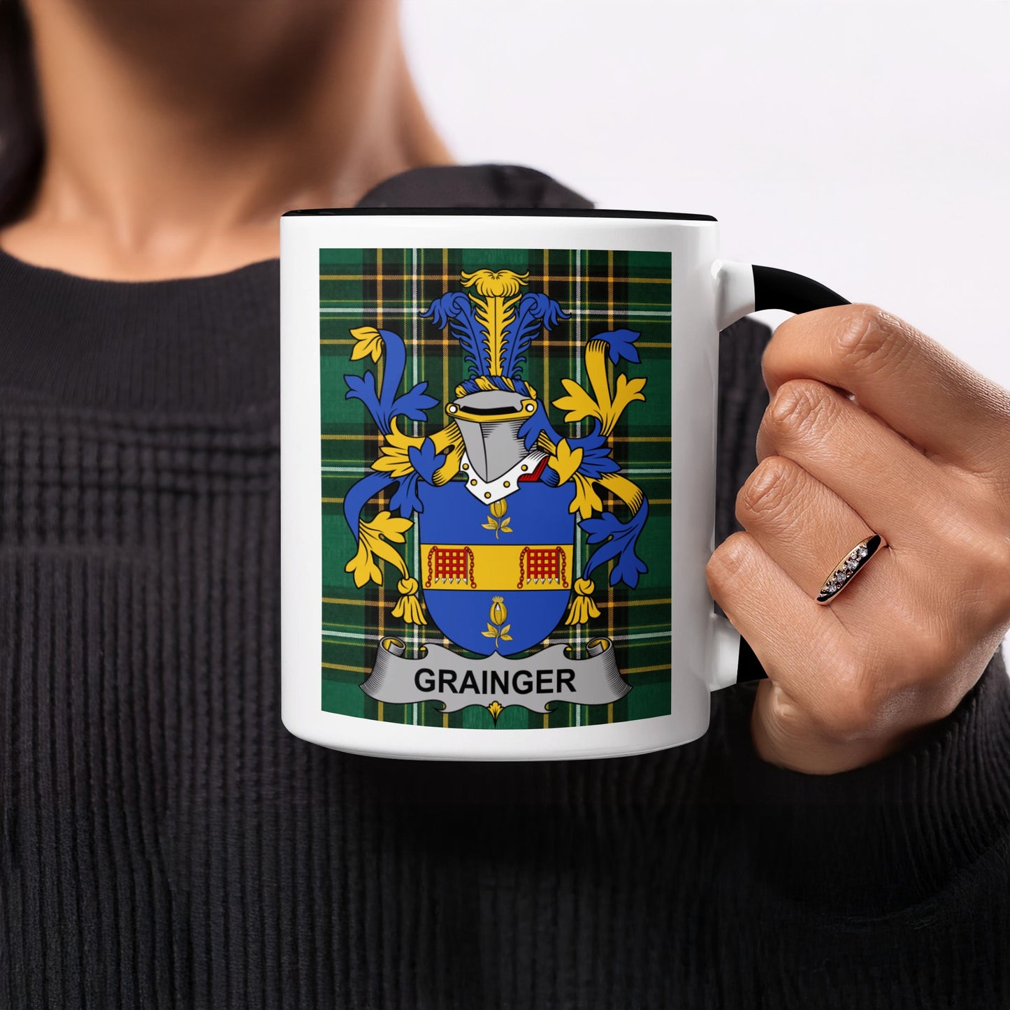 Black mug with Grainger family crest on plaid background.