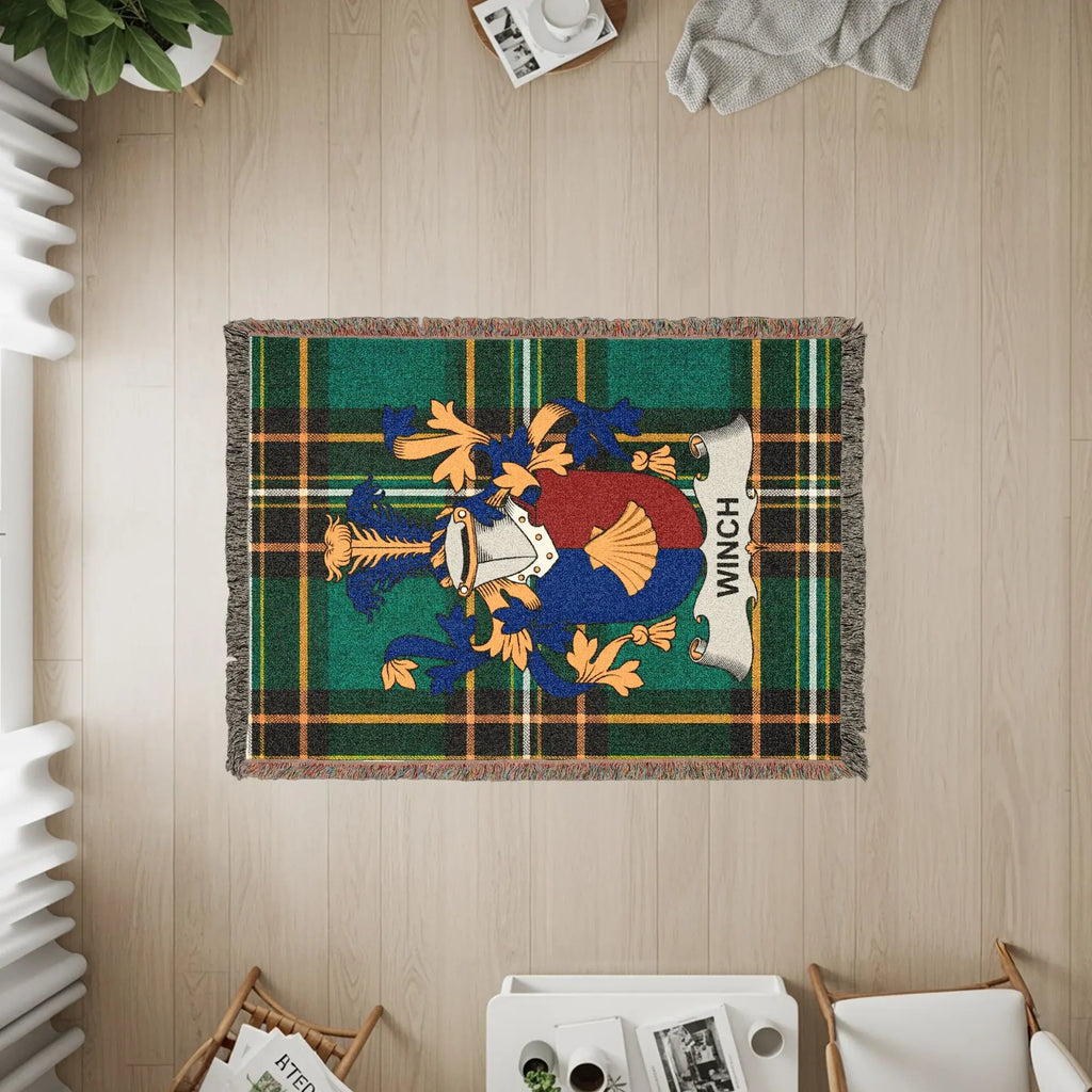 Woven throw blanket with a green and blue tartan pattern and the Winch family crest.