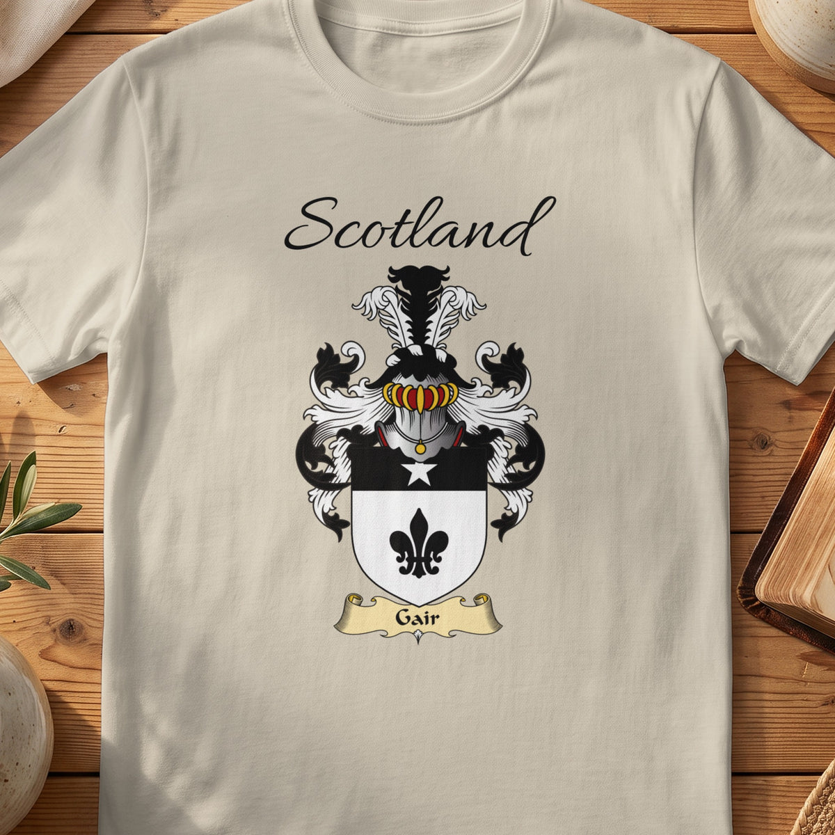 Sand Gair Scottish family shield T-shirt featuring a black fleur-de-lis on a pale shield