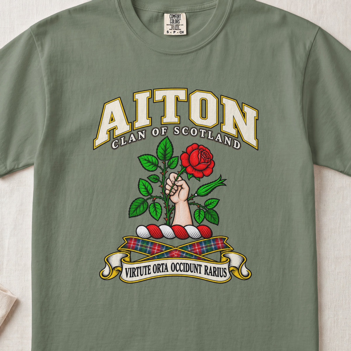 Aiton Scottish clan T-shirt in Moss, front view with a hand holding a red rose with green leaves and motto design.