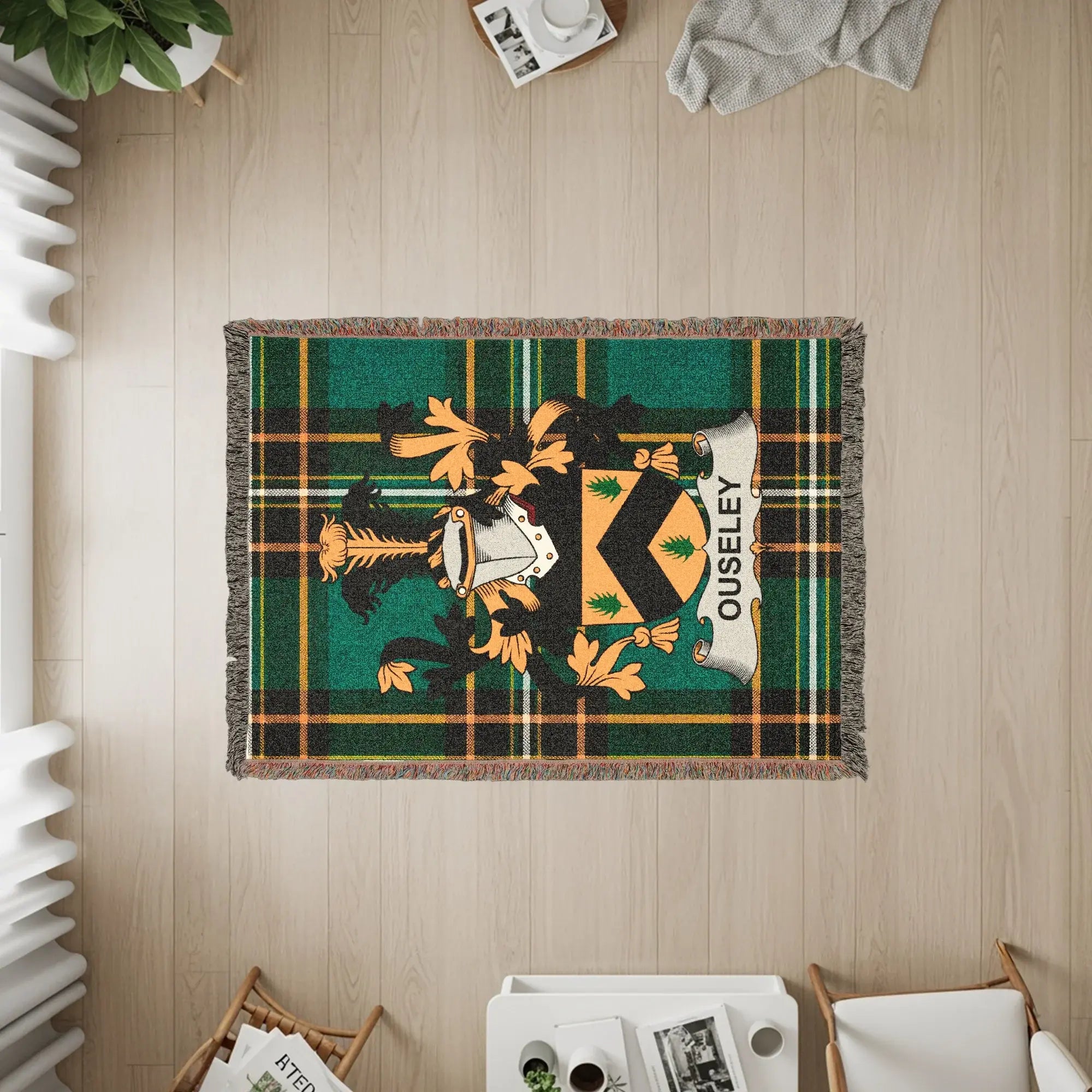 Woven blanket with Ouseley crest on green plaid pattern.