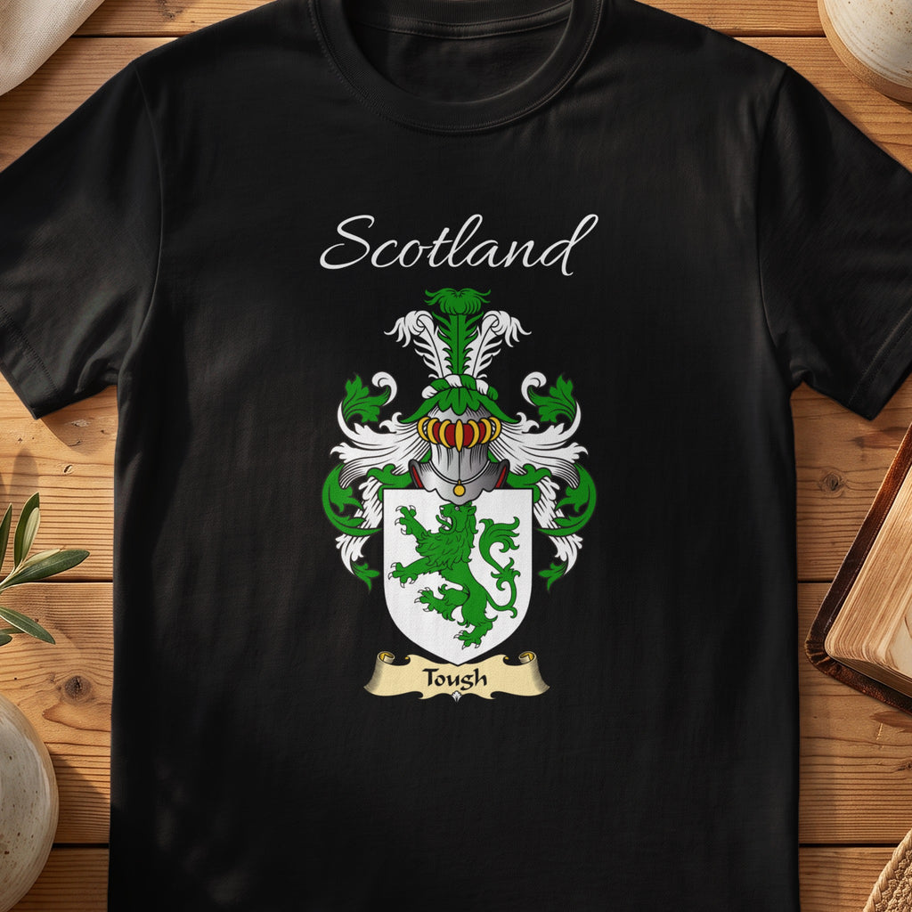 Black Tough Scottish family crest T-shirt laid flat, showing “Scotland” above a green-and-silver shield with a cross and small animal figures.