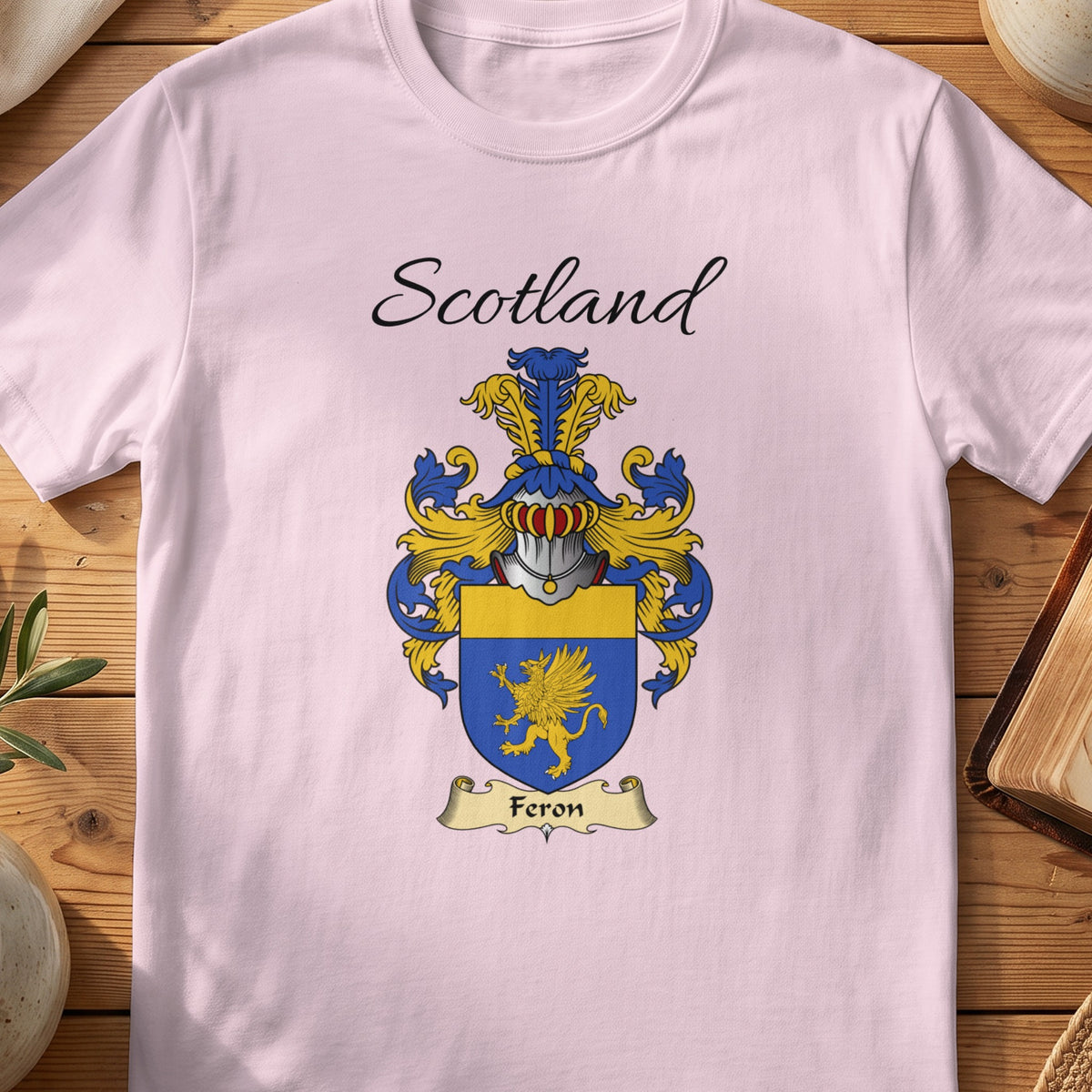 Light Pink Feron Scottish family shield T-shirt featuring a gold winged creature on blue