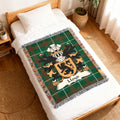 Green tartan blanket with Lloyd family crest on a bed.