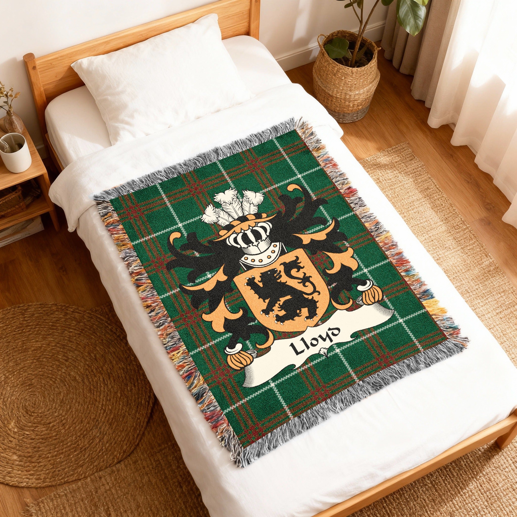 Green tartan blanket with Lloyd family crest on a bed.