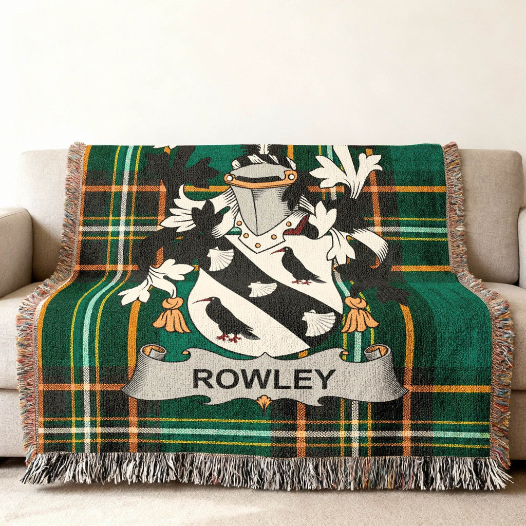 Rowley family crest on a green plaid woven throw blanket draped on a sofa.
