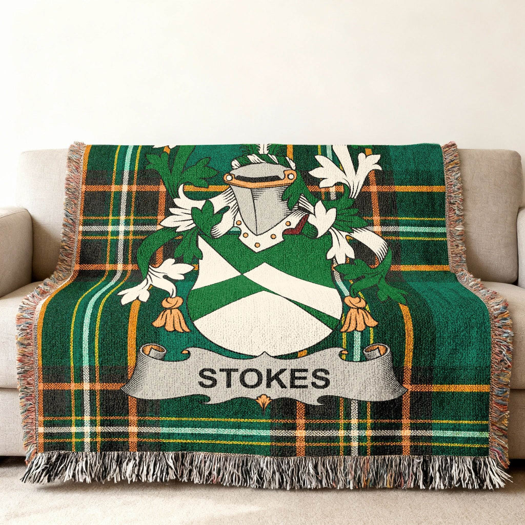 Green tartan blanket with a coat of arms and "STOKES" crest draped on a sofa.