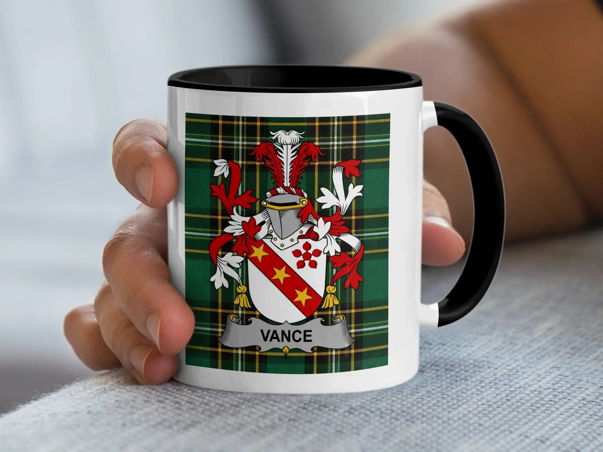 White mug with black rim featuring a Vance family crest on a tartan background.
