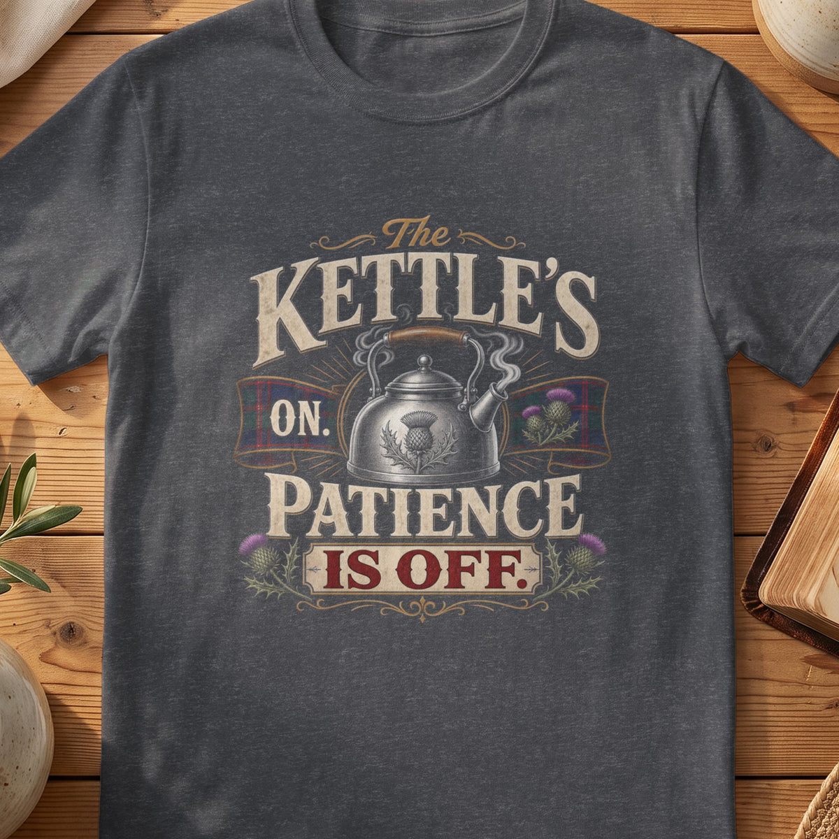 Dark grey Gildan 64000 unisex T-shirt flatlay with The Kettle's On Patience Is Off Scottish graphic design