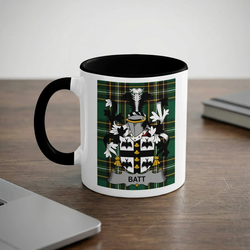 White mug with black handle featuring a green plaid crest with the name BATT.