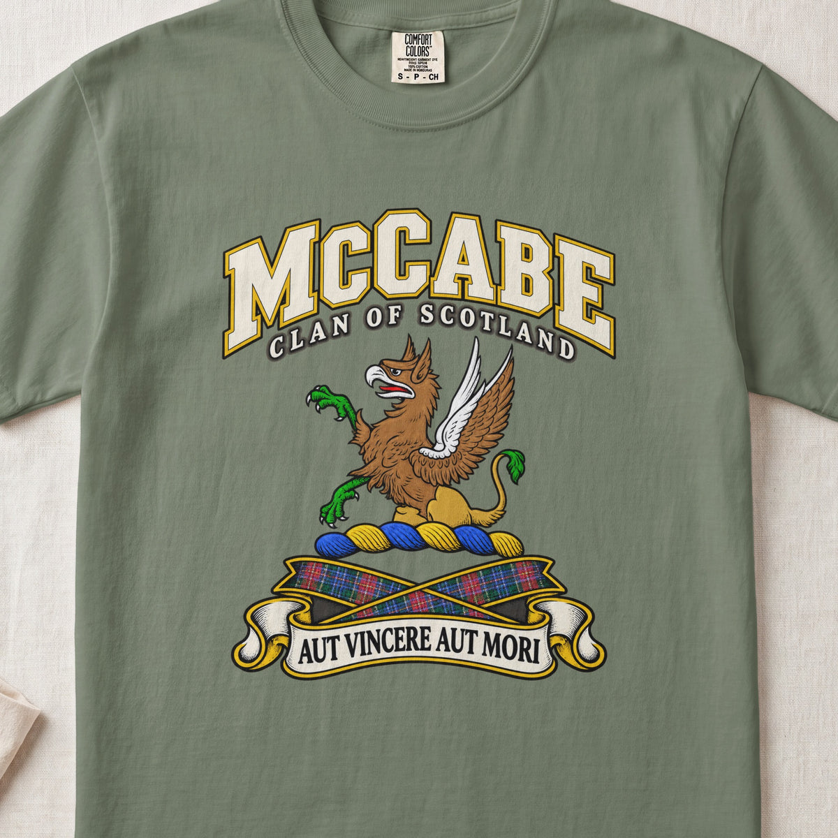 McCabe Scottish clan T-shirt in Moss, front view with a brown and gold winged griffin with green claws and motto banner.
