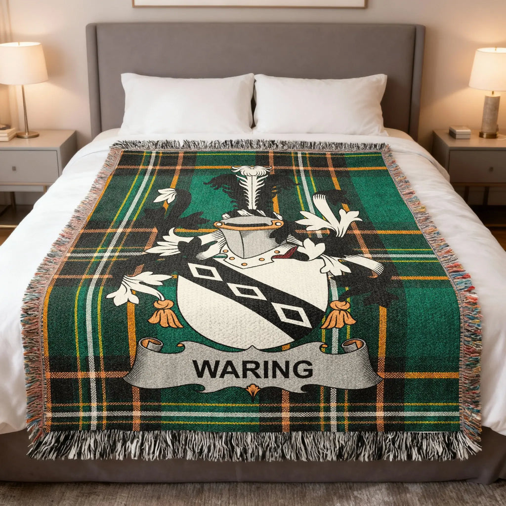 Waring family crest on a green tartan blanket on a bed.