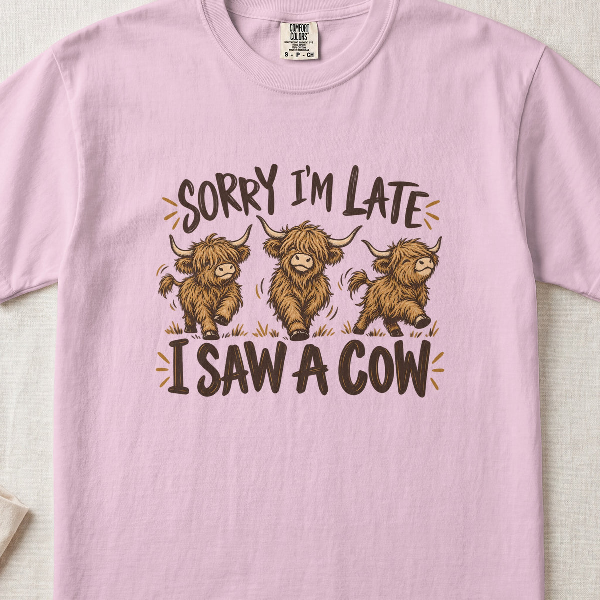 Sorry I'm Late, I Saw a Cow Highland cow design on a Blossom Comfort Colors 1717 T-shirt, flat lay