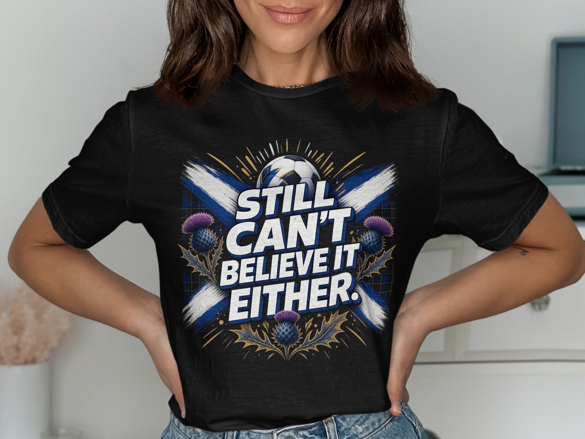 Black t-shirt with Scottish flag and "Still Can't Believe It Either" text.