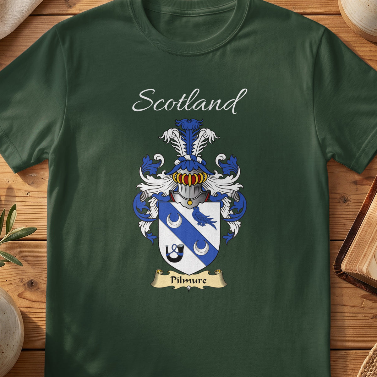 Forest Green Pilmure Scottish T-shirt laid flat with coat of arms artwork and “Scotland” text.