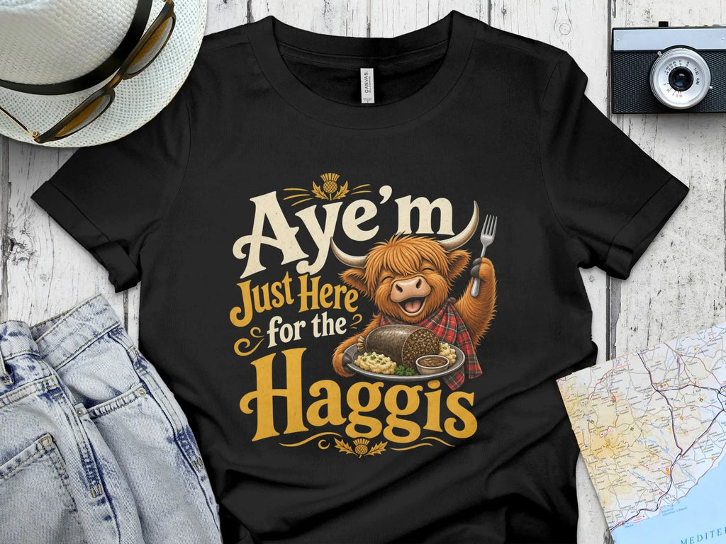 T-shirt with cartoon highland cow and text "Aye'm just here for the Haggis".