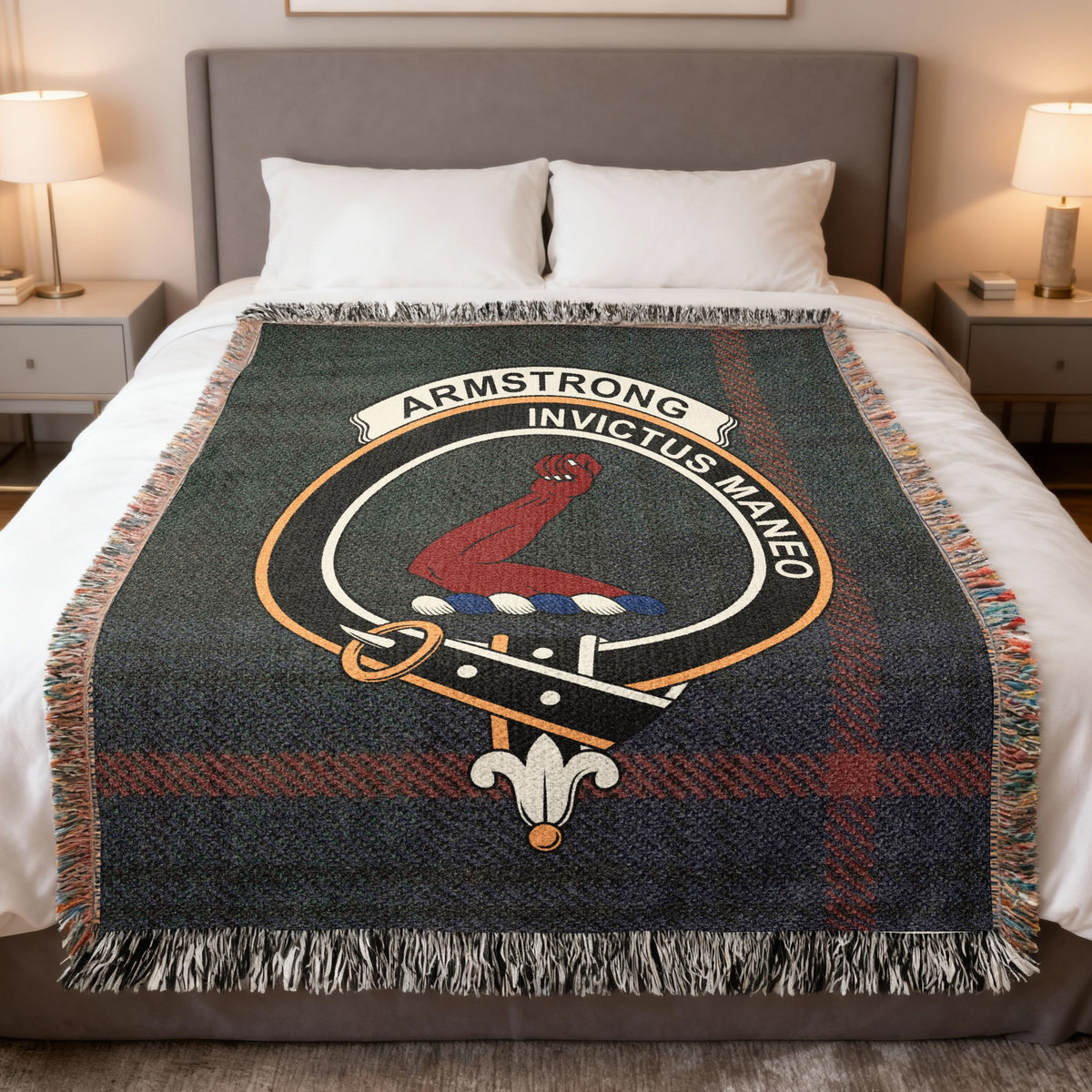 Armstrong woven blanket displayed on a bed, with a red armoured arm on a dark green and red tartan background