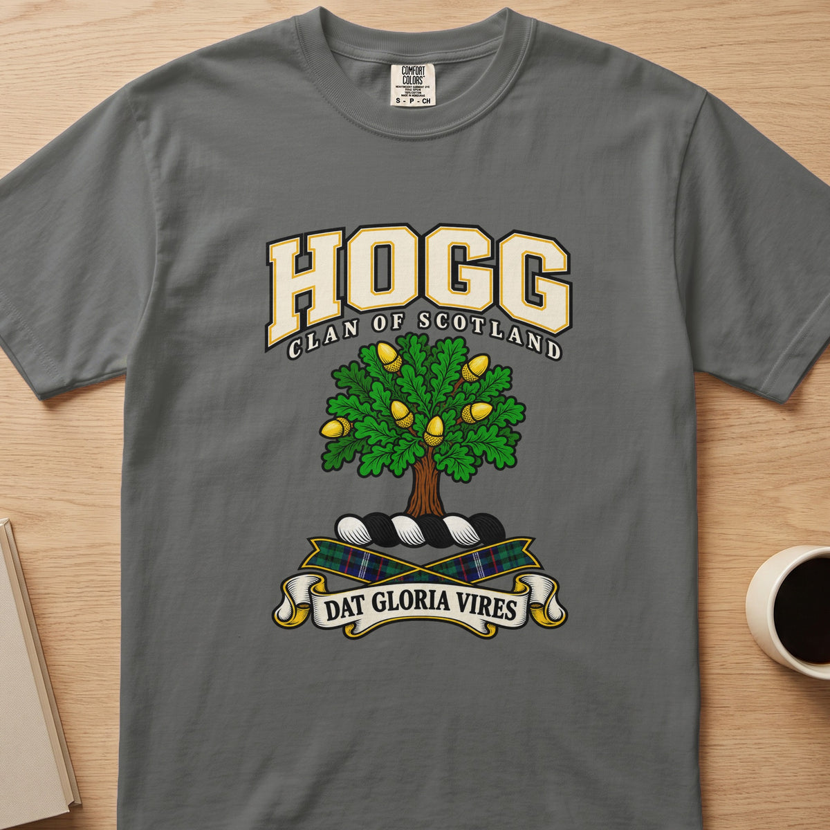 Hogg clan crest with green tree with gold details on a gray Comfort Colors T-shirt, front view