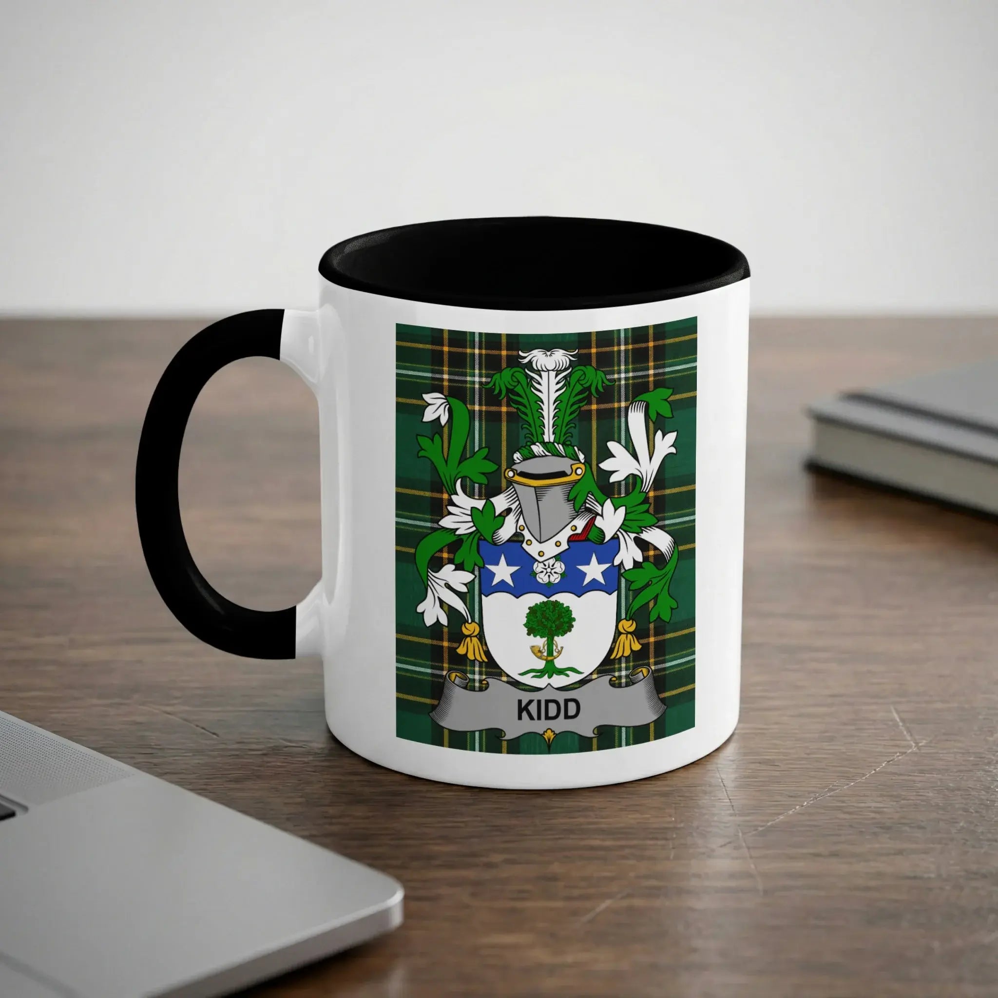 White mug with black handle featuring the Kidd family crest on a green tartan background.