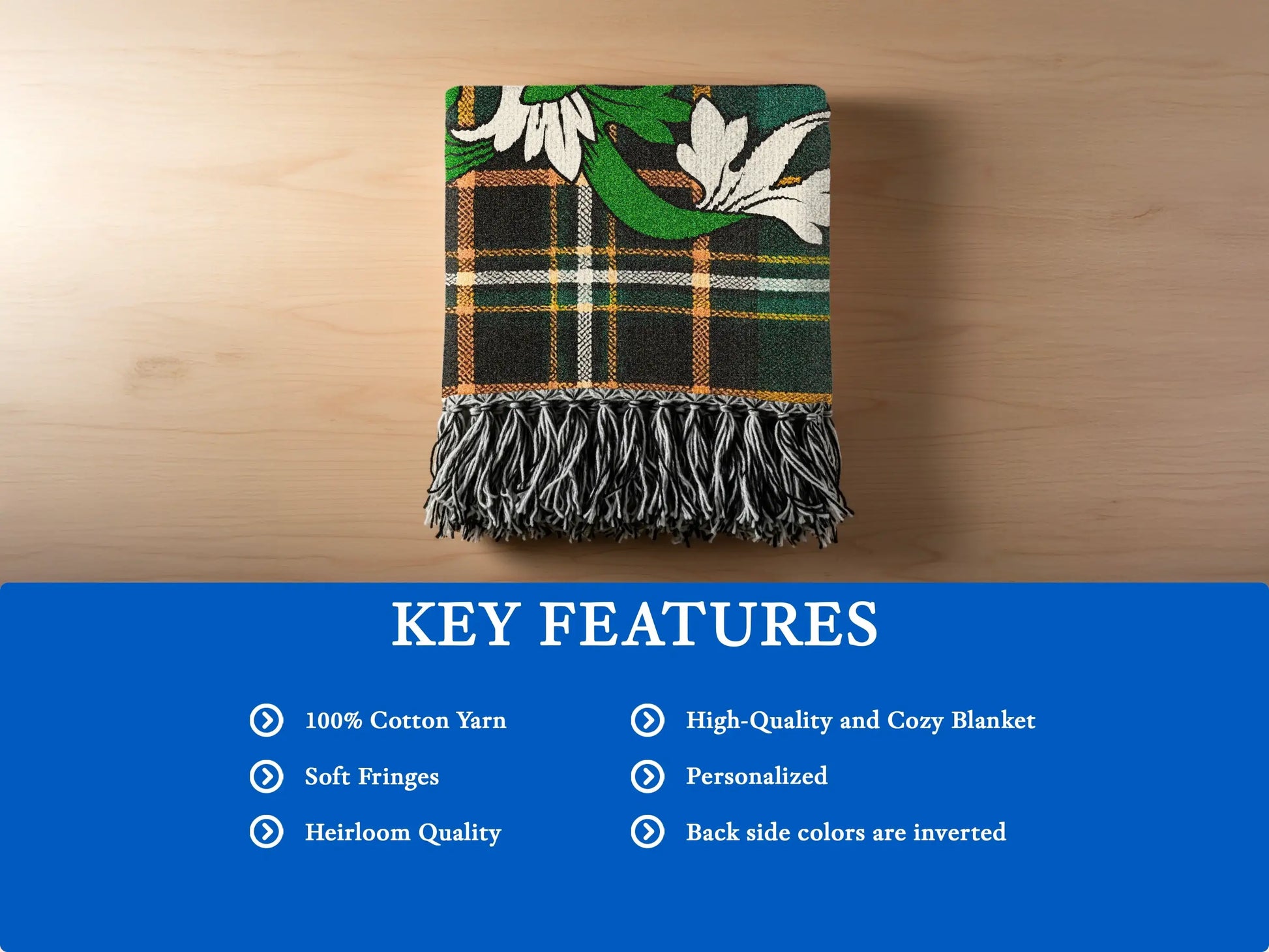 Green and black plaid throw blanket with white floral accents and fringe.